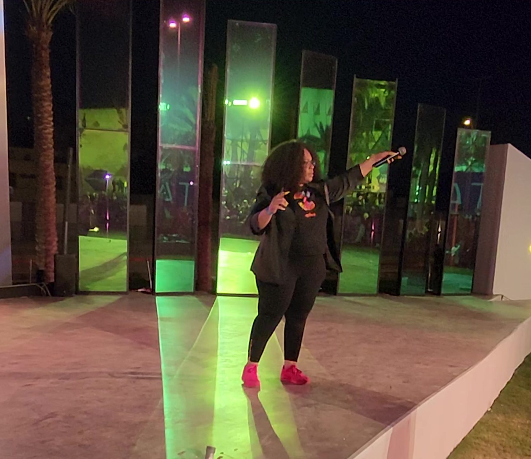 Nina Thomas speaking on the open-air RiseUp Summit stage at night